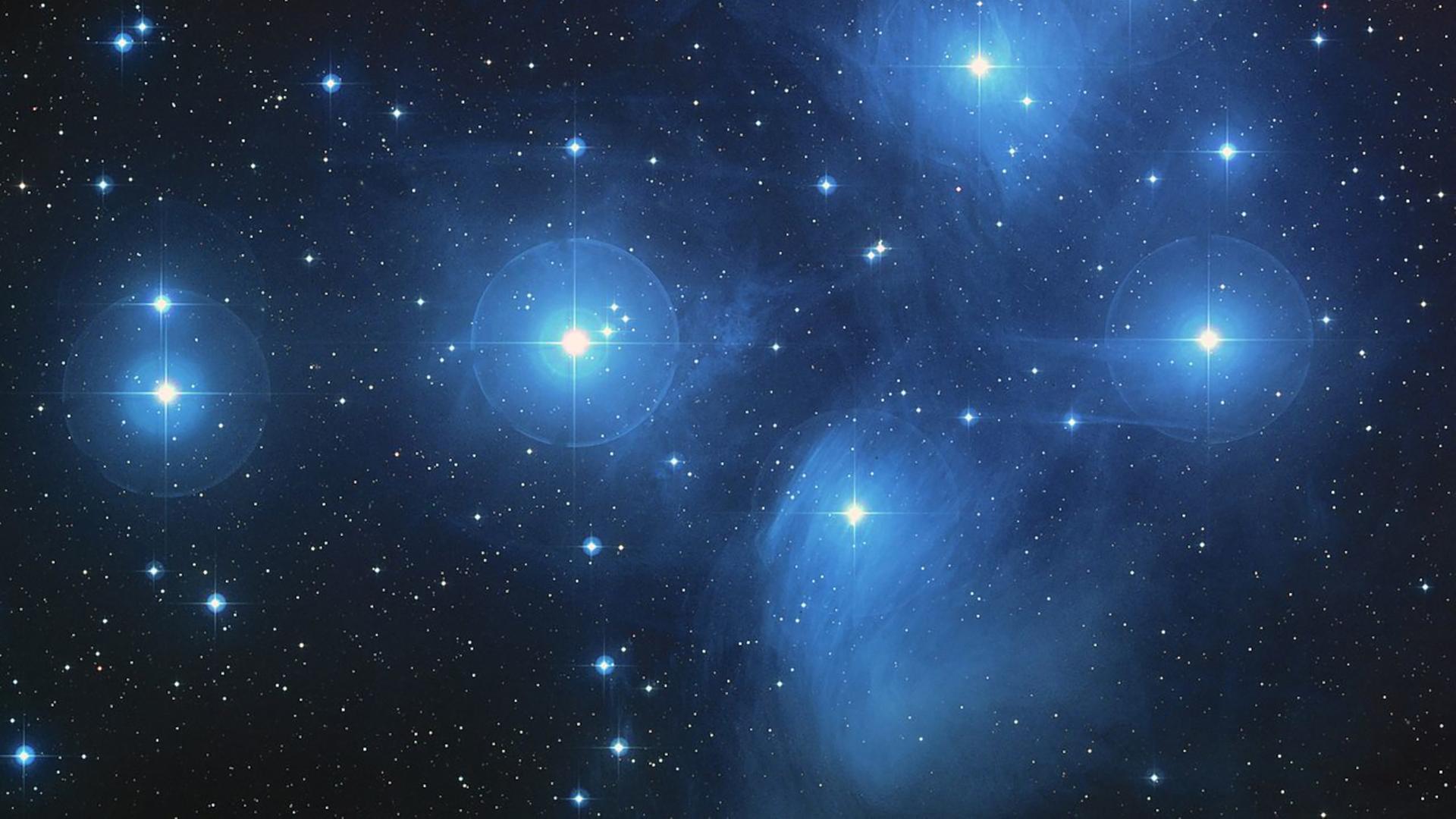 Blau schimmernde Sterne am schwarzen Nachhimmel
