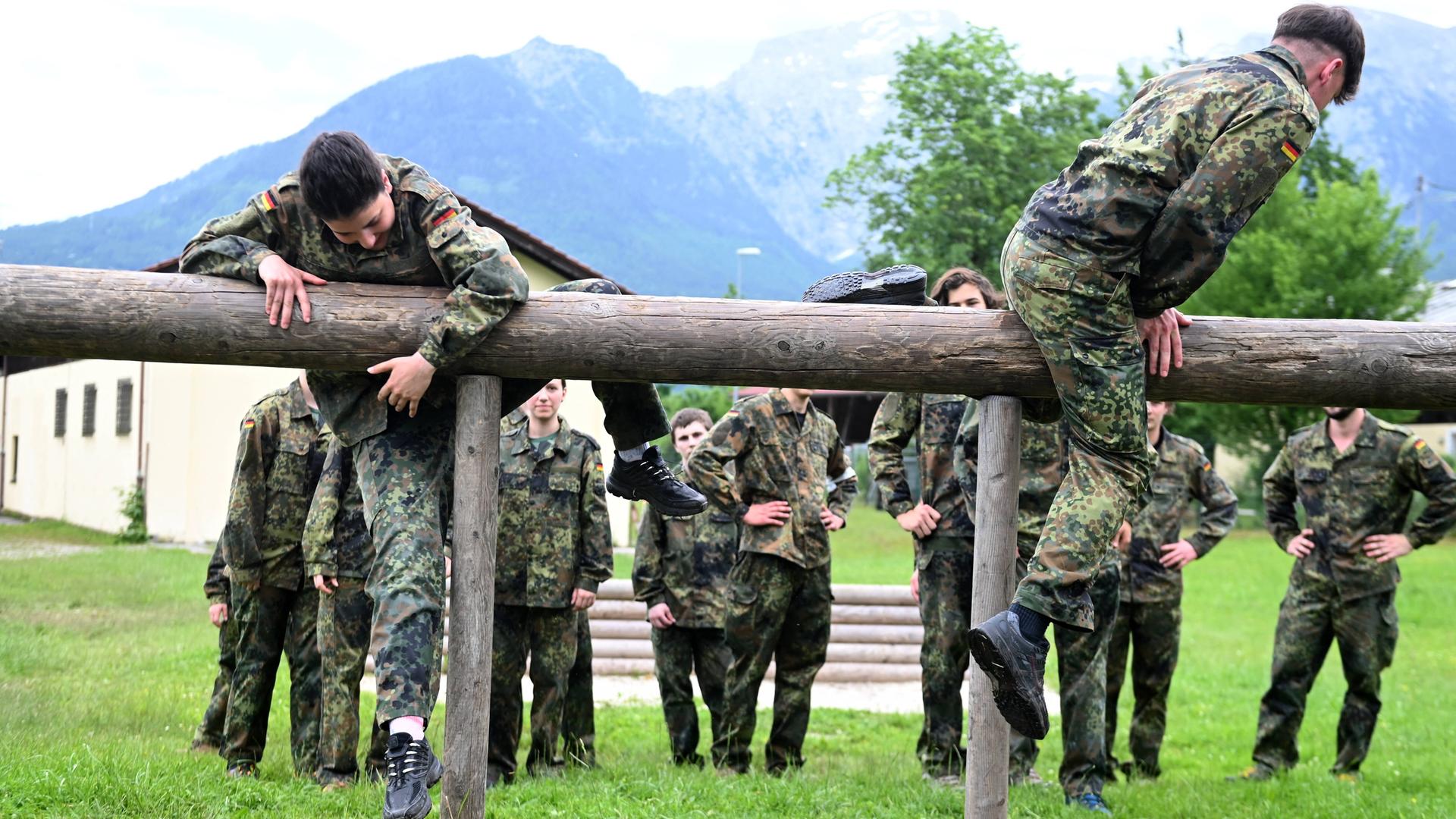 Jägerkaserne in Berchtesgaden/Bischofswiesen: Junge Männer und Frauen in Flecktarn-Overalls balancieren auf Holzbohlen.