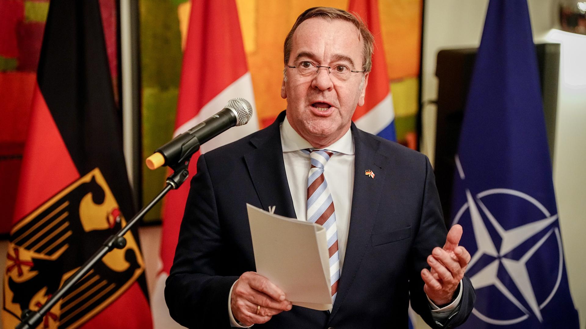 Boris Pistorius (SPD), Bundesminister der Verteidigung, spricht bei einem Empfang des deutschen Botschafters zu den Gästen - hinter ihm die Flaggen der Länder, die er besuchen wird.