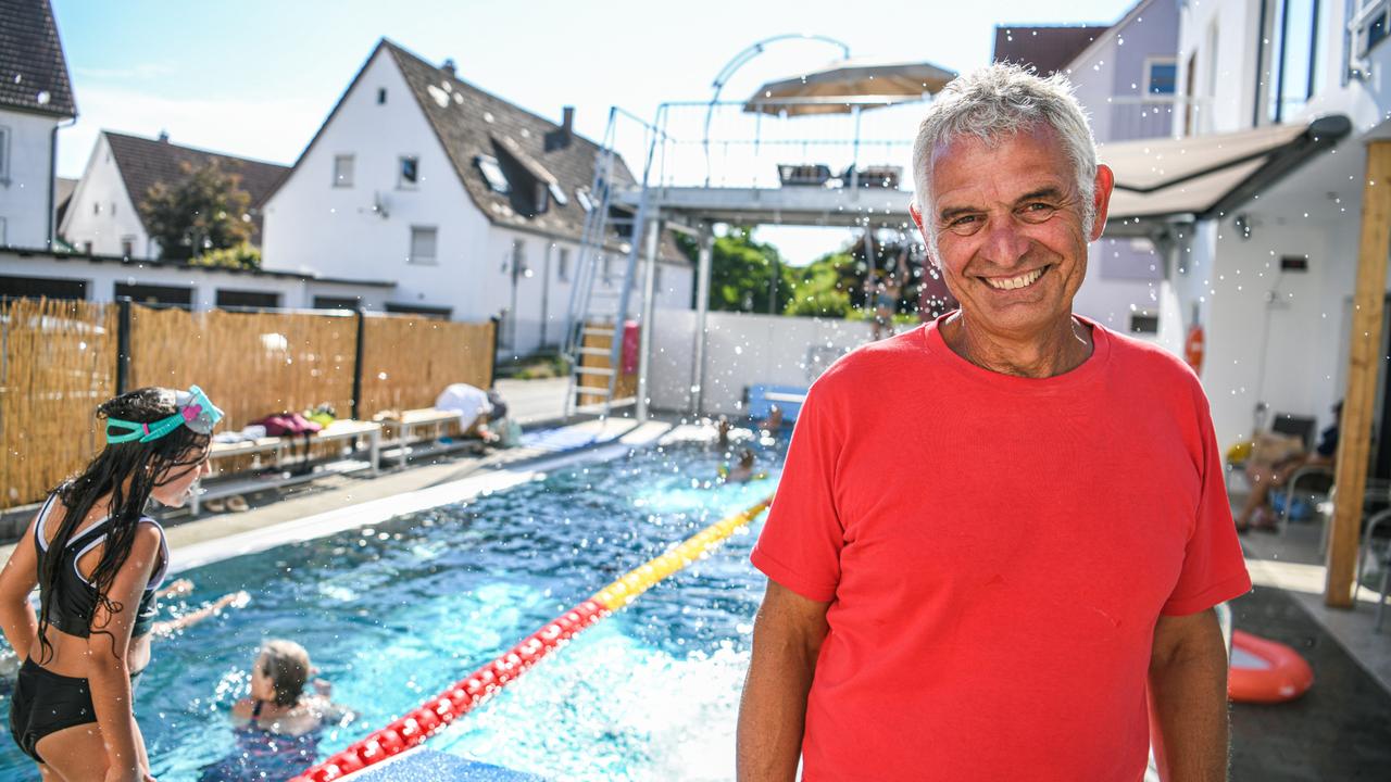 Achim Gall steht mit einem breiten Lächeln vor seinem Schwimmbecken.