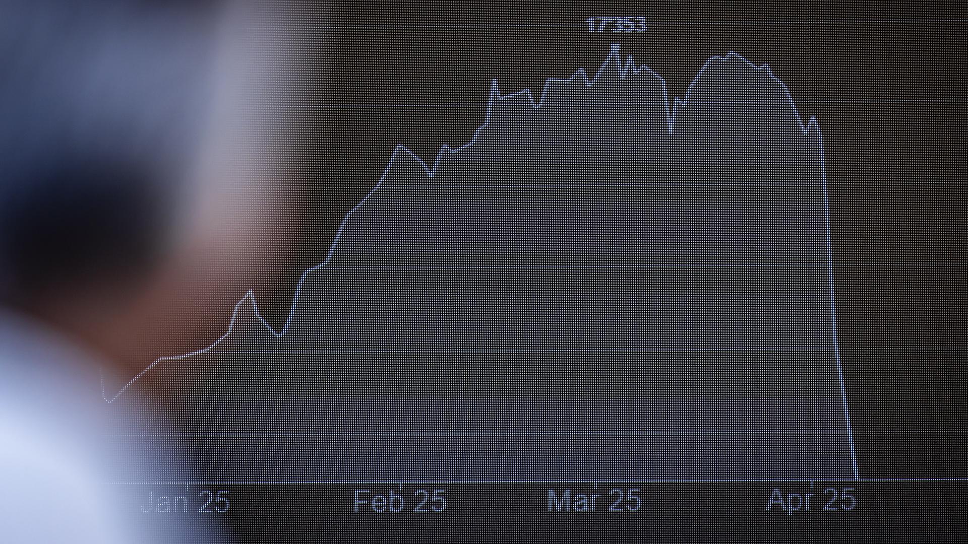 Ein Mann betrachtet an einer LED-Wand in der Neuen Börse Zürich-West die abgestürzte Kurve der  Börsenkurse.