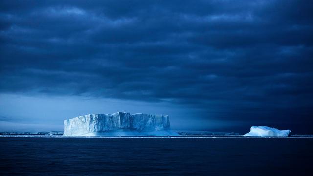 Eisberge im Meer vor einem dunklen Himmel
