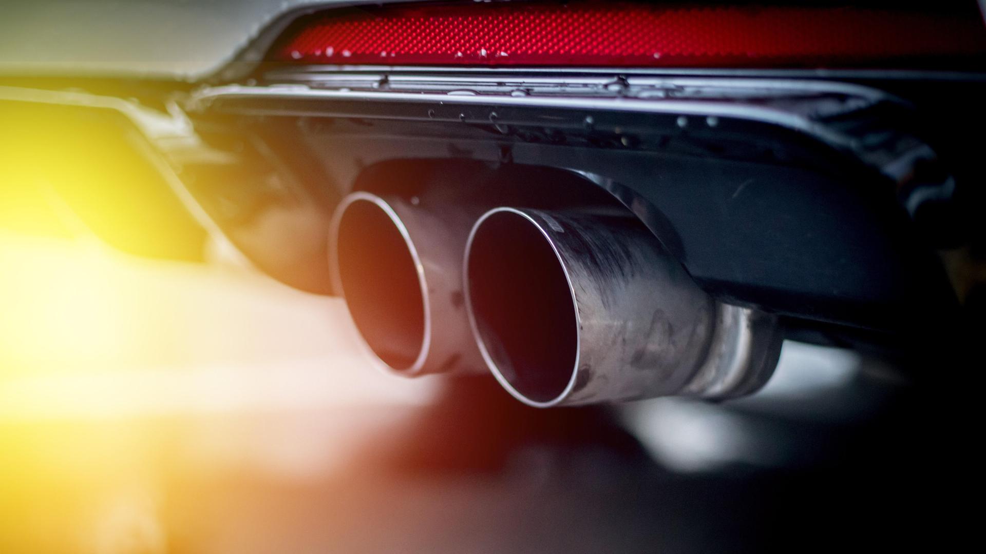 Nahaufnahme eines Auspuffrohrs eines Autos im Sonnenlicht