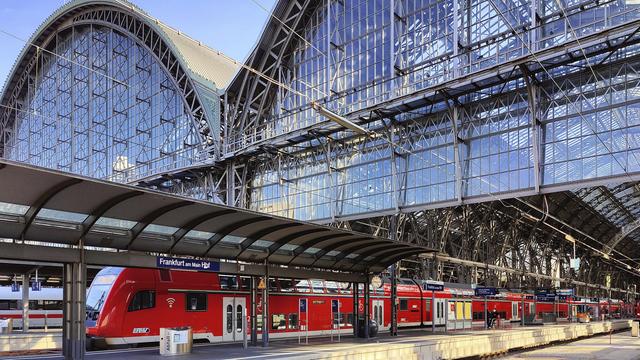 Blick auf den Hauptbahnhof in Frankfurt am Main mit Nahverkehrszug und Bahnsteighallen.