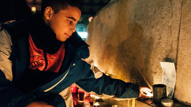 Ein junger Mann zündet eine Kerze an.