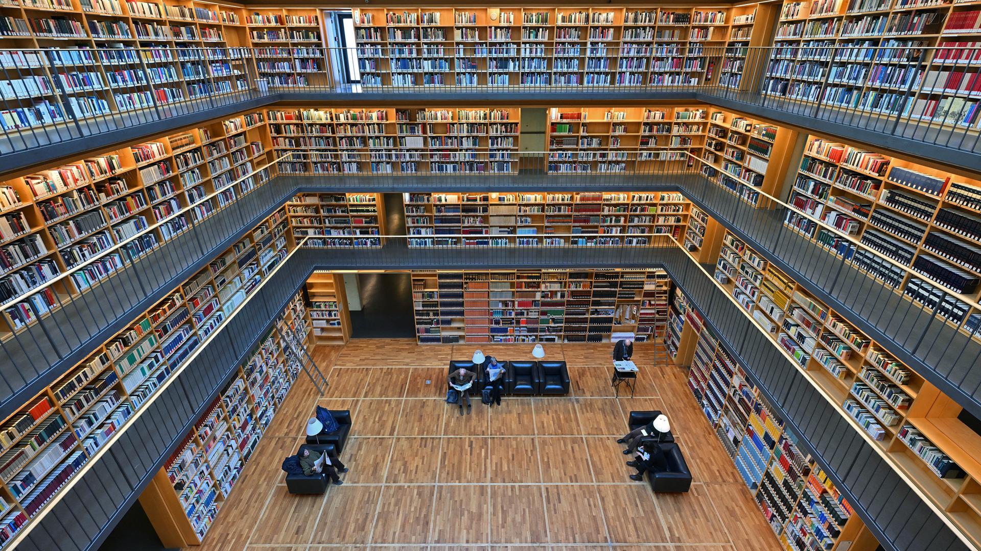 Foto in eine große Bibliothek. Auf mehreren Etagen sind Bücher in Regalen sortiert. Der Bücherkubus befindet sich im Studienzentrum der Herzogin Anna Amalia Bibliothek in Weimar.