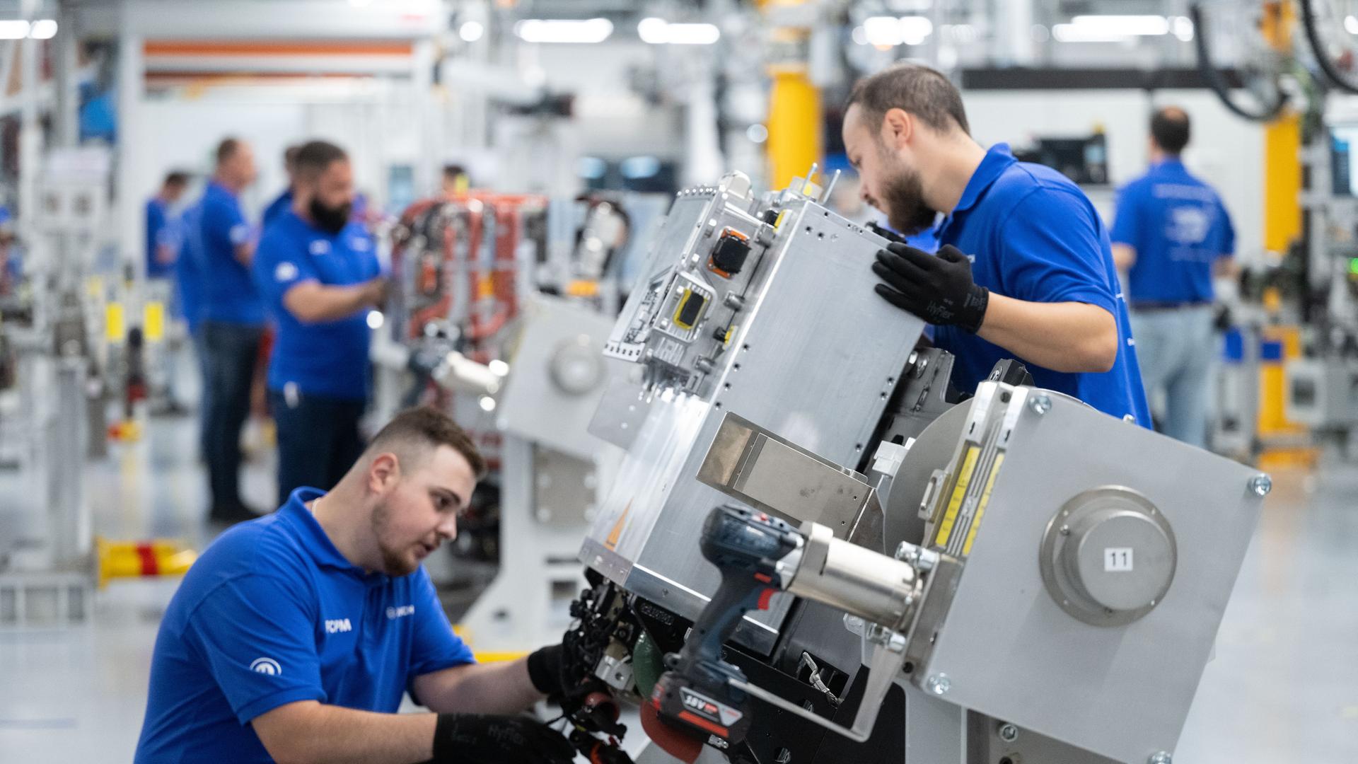 Mitarbeiter der Robert Bosch GmbH montieren in der Fertigung Brennstoffzellen-Antriebssysteme für die Stromerzeugung aus Wasserstoff in Fahrzeugen.