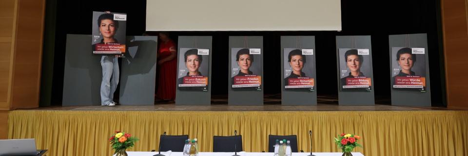 Auf einer Bühne hängen mehrere Wahlplakate mit dem Porträt von Sahra Wagenknecht. Auf einer Bühne hängen mehrere Wahlplakate mit dem Porträt von Sahra Wagenknecht.
