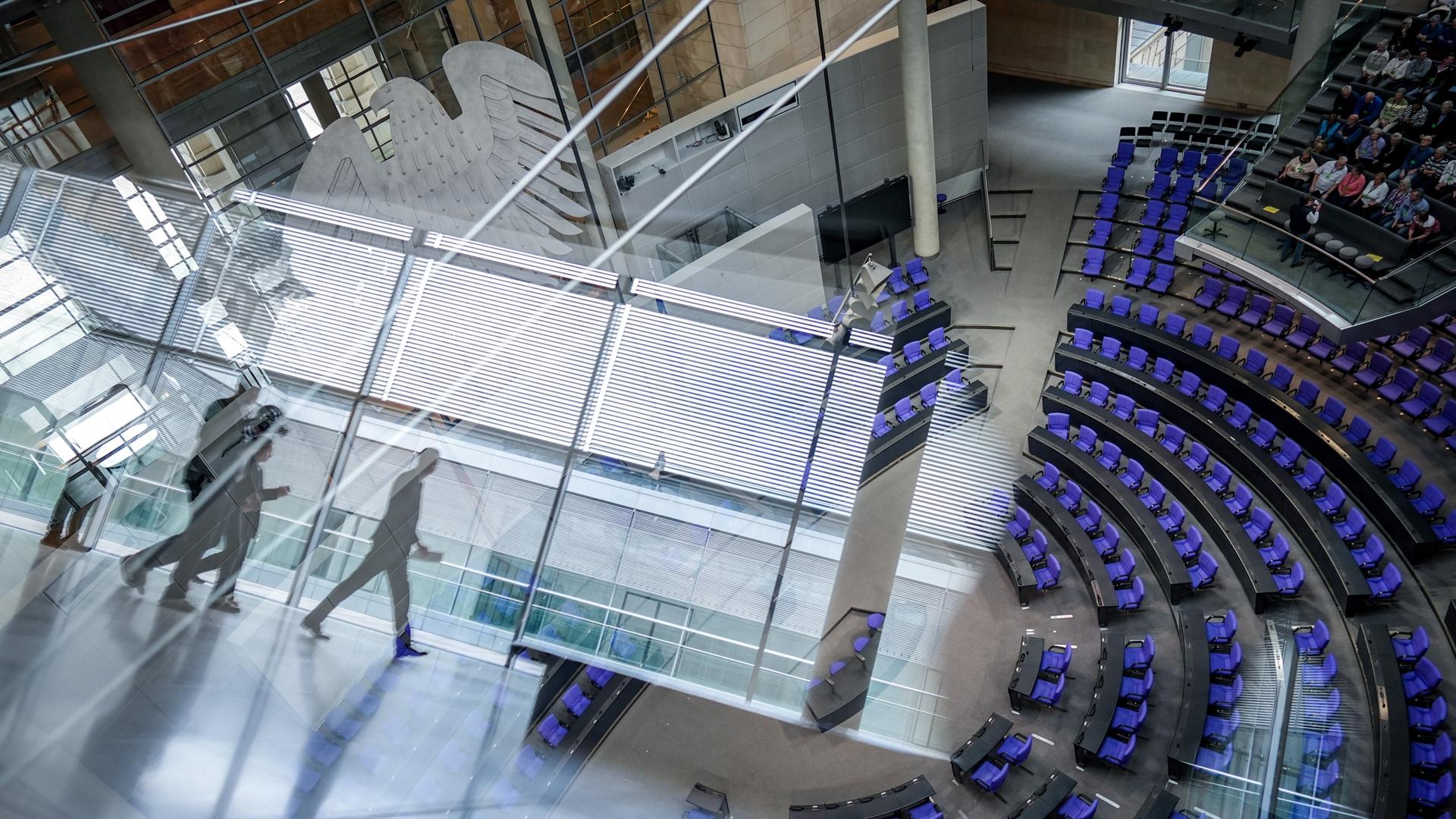 Blick in den Plenarsaal durch eine spiegelnde Fensterscheibe.