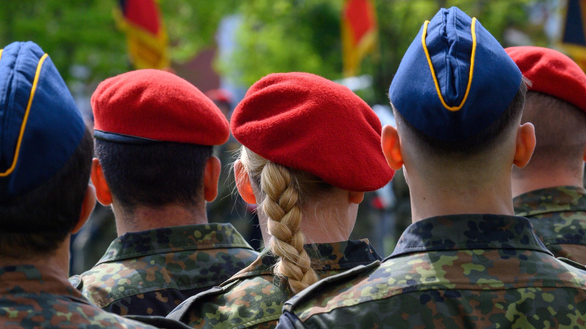 Soldatinnen und Soldaten der Bundeswehr stehen im Goethepark in Burg in Sachsen-Anhalt, fotografiert von hinten.