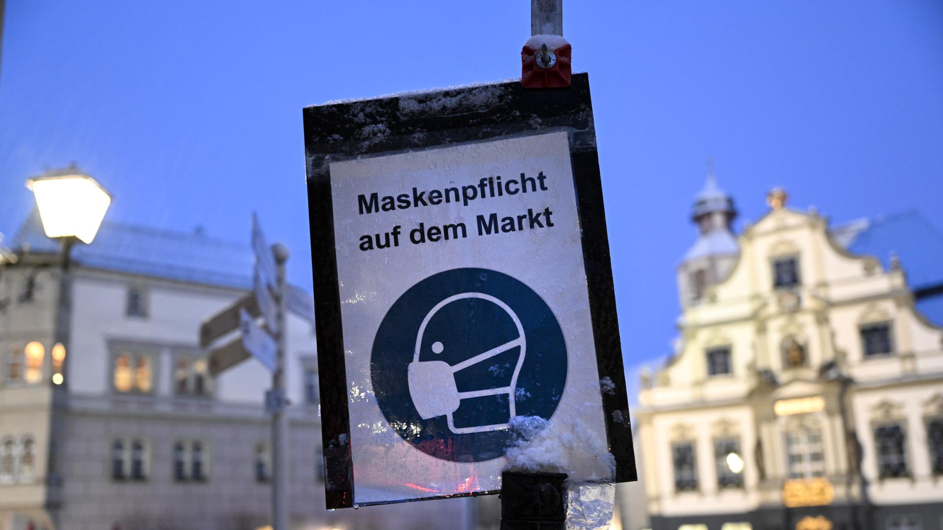 Ein Schild im Januar 2022 wies aufgrund der Corona-Pandemie auf die Maskenpflicht auf dem Marktplatz von Wangen im Allgäu hin.