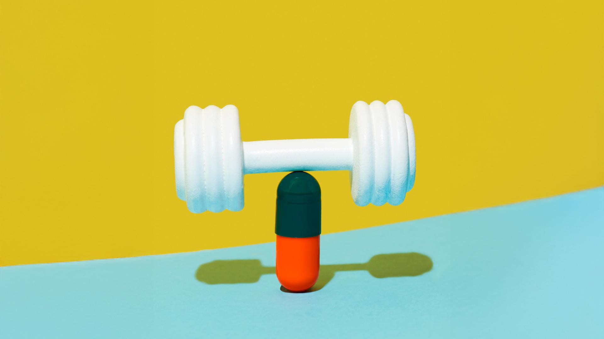 Eine weiße Hantel balanchiert auf einer grünroten Pille auf einem gelben und blauen Hintergrund.