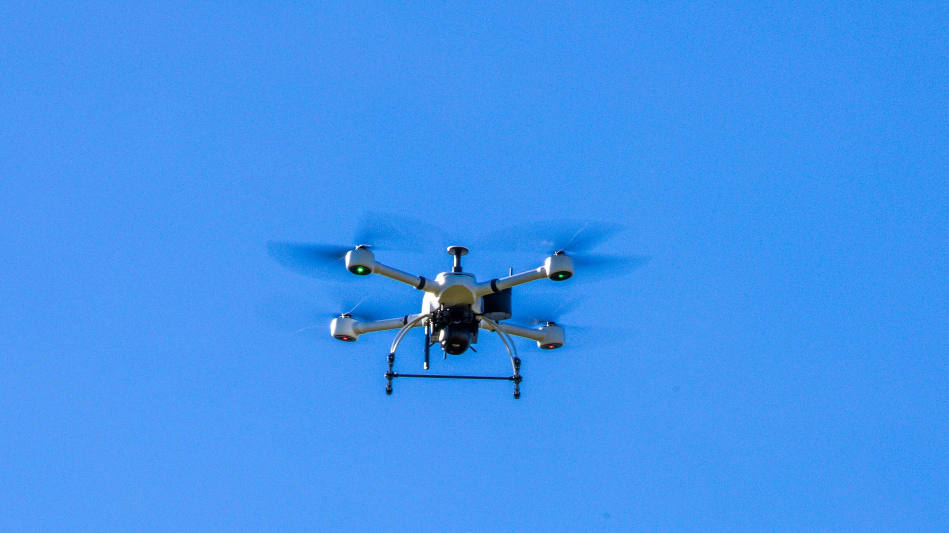 Eine Drohne schwebt im blauen Himmel 