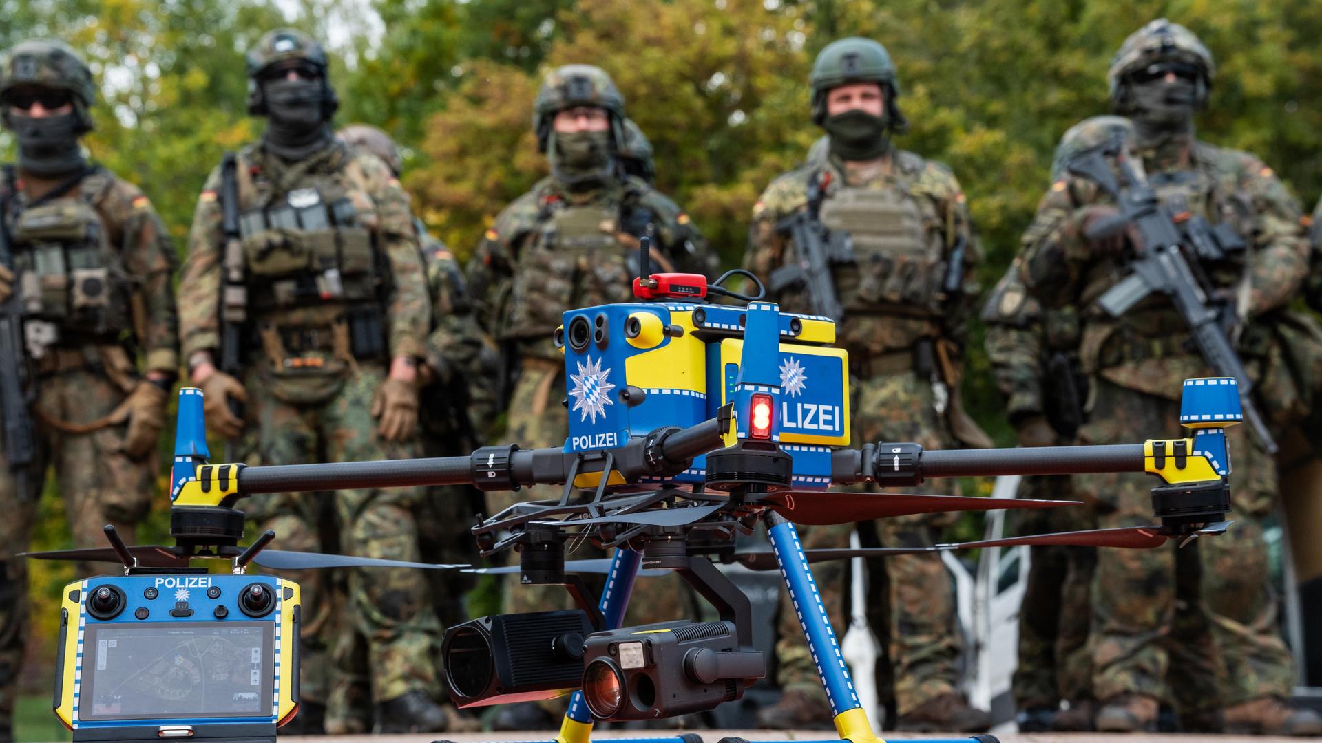 Gemeinsame Einsatzübung der Bayerischen Polizei und der Deutschen Bundeswehr RoadTEX 2025 (Übung Anschlag im Verkehrsraum). Eine Polizeidrohne steht einsatzbereit vor einer Formation von Bundeswehrsoldaten