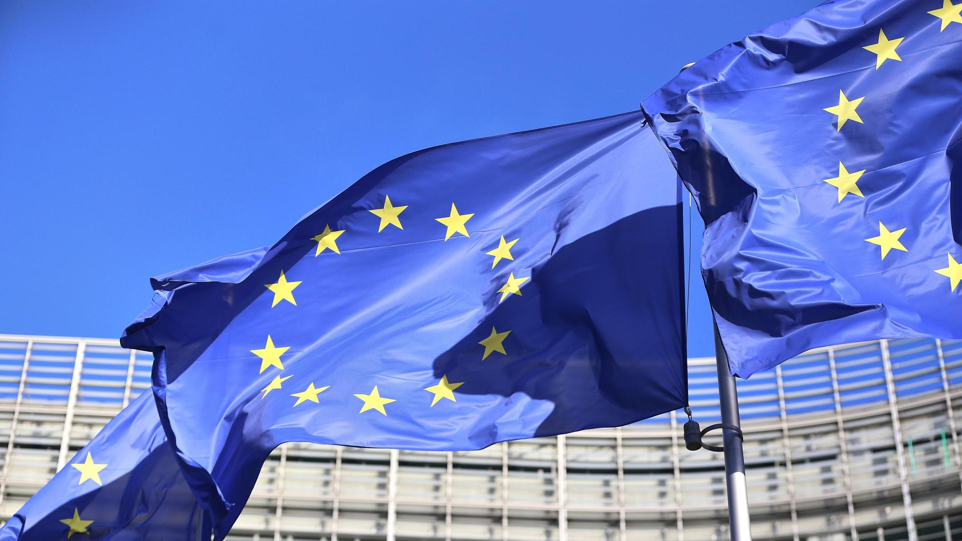 Vor Gebäuden der EU in Brüssel wehen Europa-Flaggen im Wind.