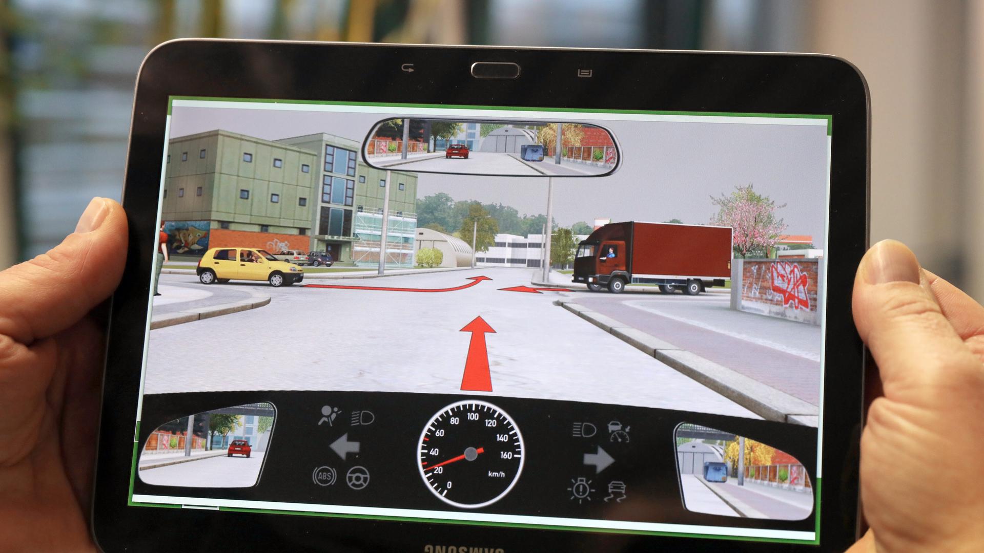 Bei einer theoretischen Führerscheinprüfung zeigt der Prüfer ein Tablet mit einer Prüfungsfrage.