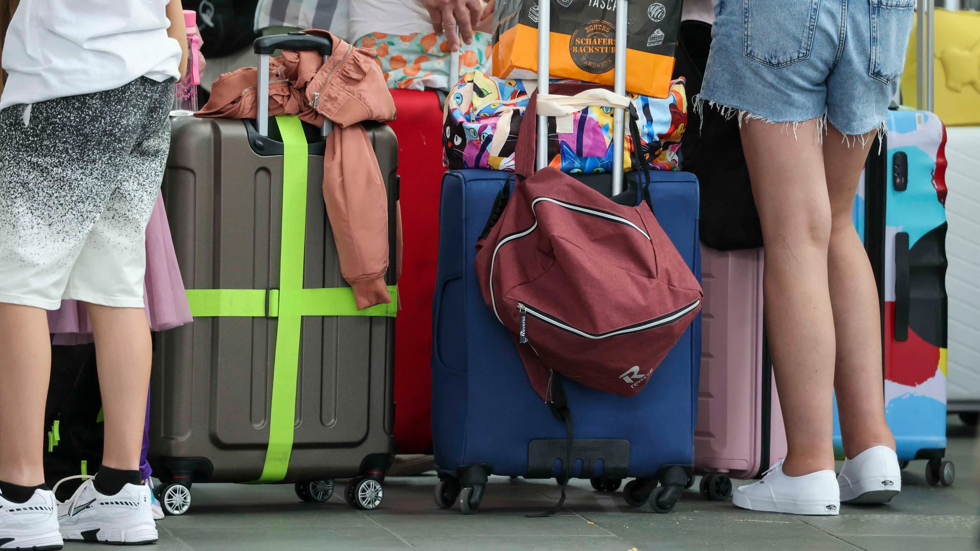 Flugreisende warten mit ihren Koffern am Check-In im Flughafen Leipzig-Halle.