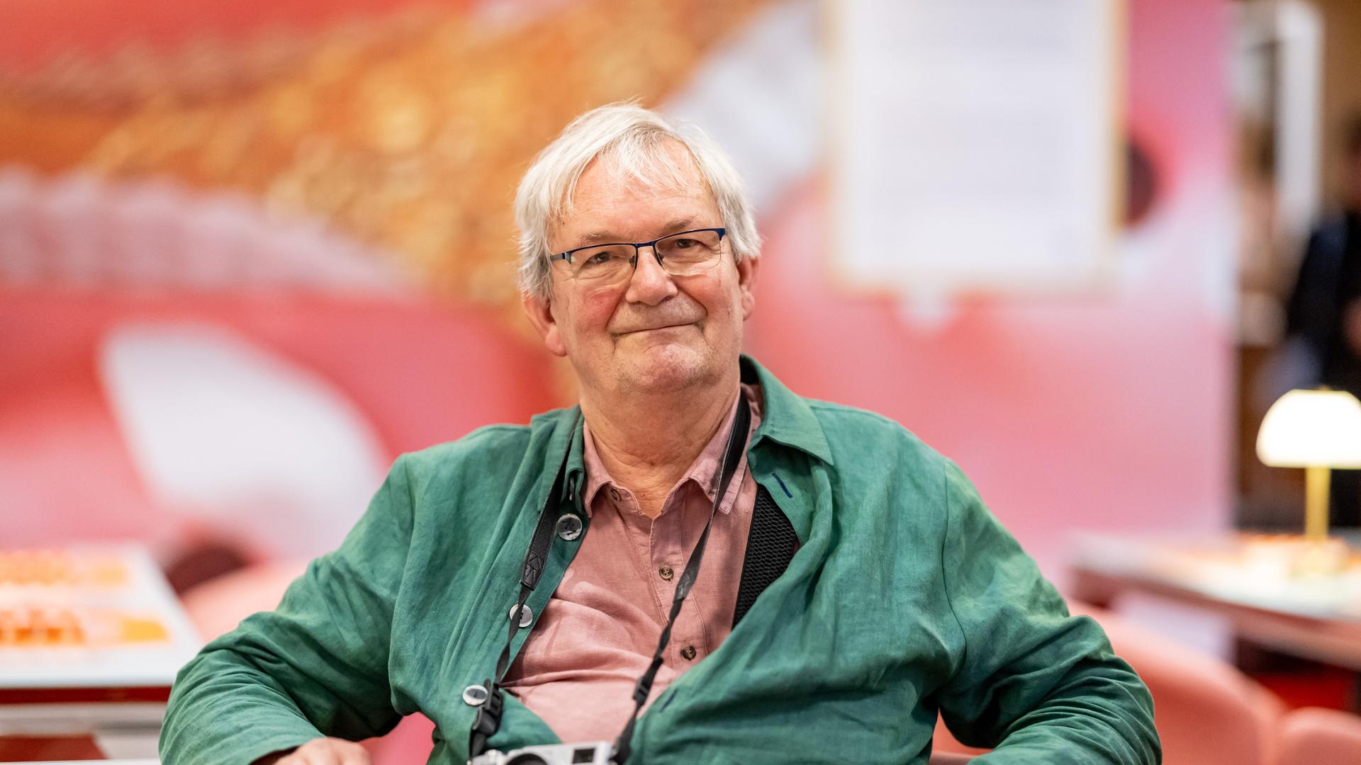 Der britische Magnum-Fotograf Martin Parr sitzt in der Ausstellung "Grand Hotel Parr" - Fotobücher von Martin Parr, im Neuen Museum Nürnberg (NMN) im "Dining Room". 