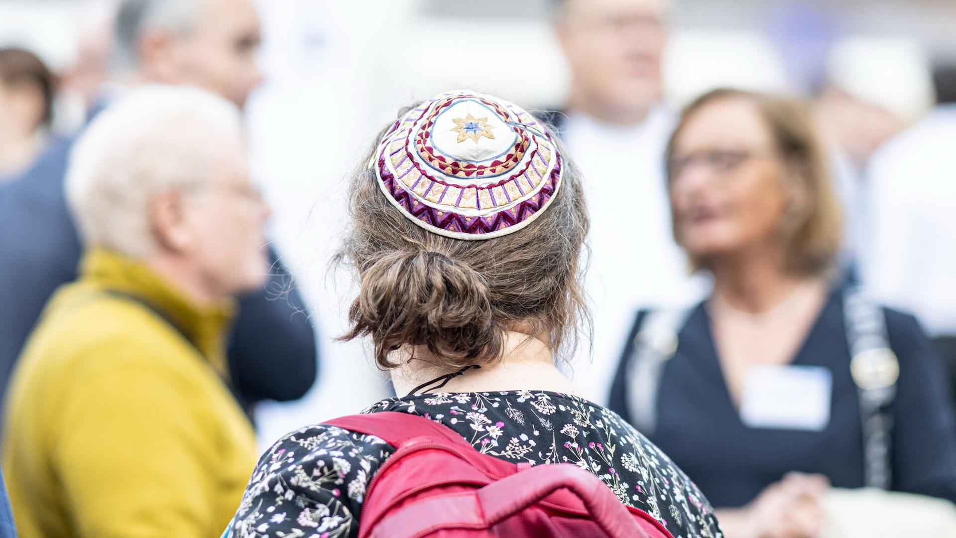 Eine Frau mit Kippa, die den Sommerempfang der jüdischen Gemeinde in der Neuen Synagoge Berlin besucht, ist von hinten zu sehen.