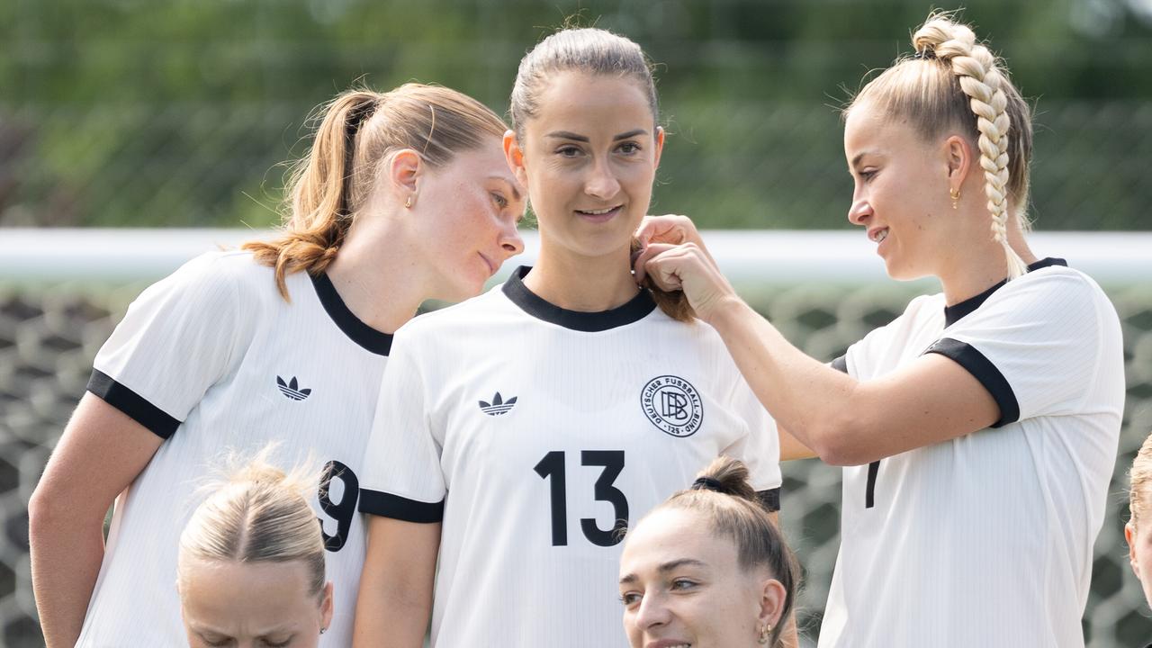 Die Fußballerinnen Sjoeke Nüsken (l) und Giulia Gwinn (r) kümmern sich um die Haare von Teamkollegin Sara Däbritz.