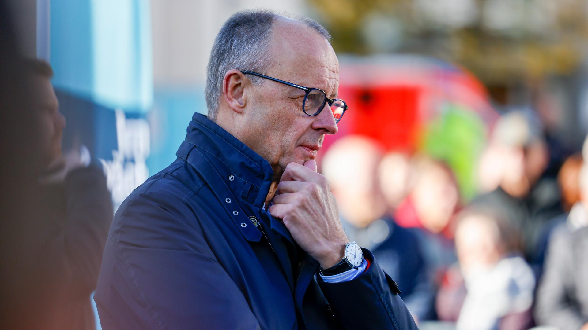 Bundeskanzler Friedrich Merz (CDU) steht mit einer Jacke draußen und hört sich beim Bürgergespräch Fragen der Zuschauer an.