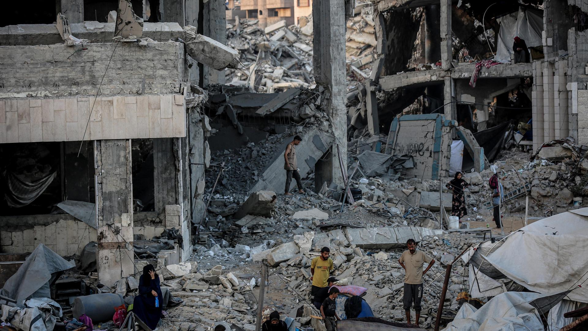 Menschen laufen durch die Trümmer eines Gebäudes, das durch einen israelischen Luftangriff vollkommen zerstört wurde. 