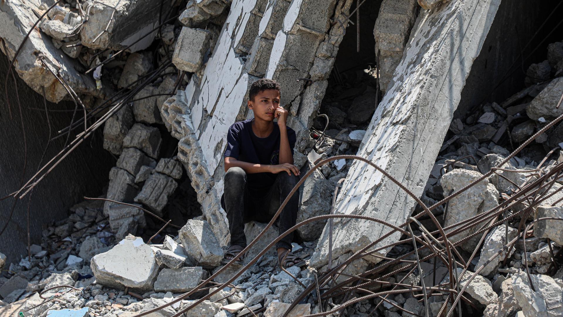 Eine Junge sitzt nach einem israelischen Luftangriff im Gaza-Streifen auf dem Trümmerhaufen eines Gebäudes.