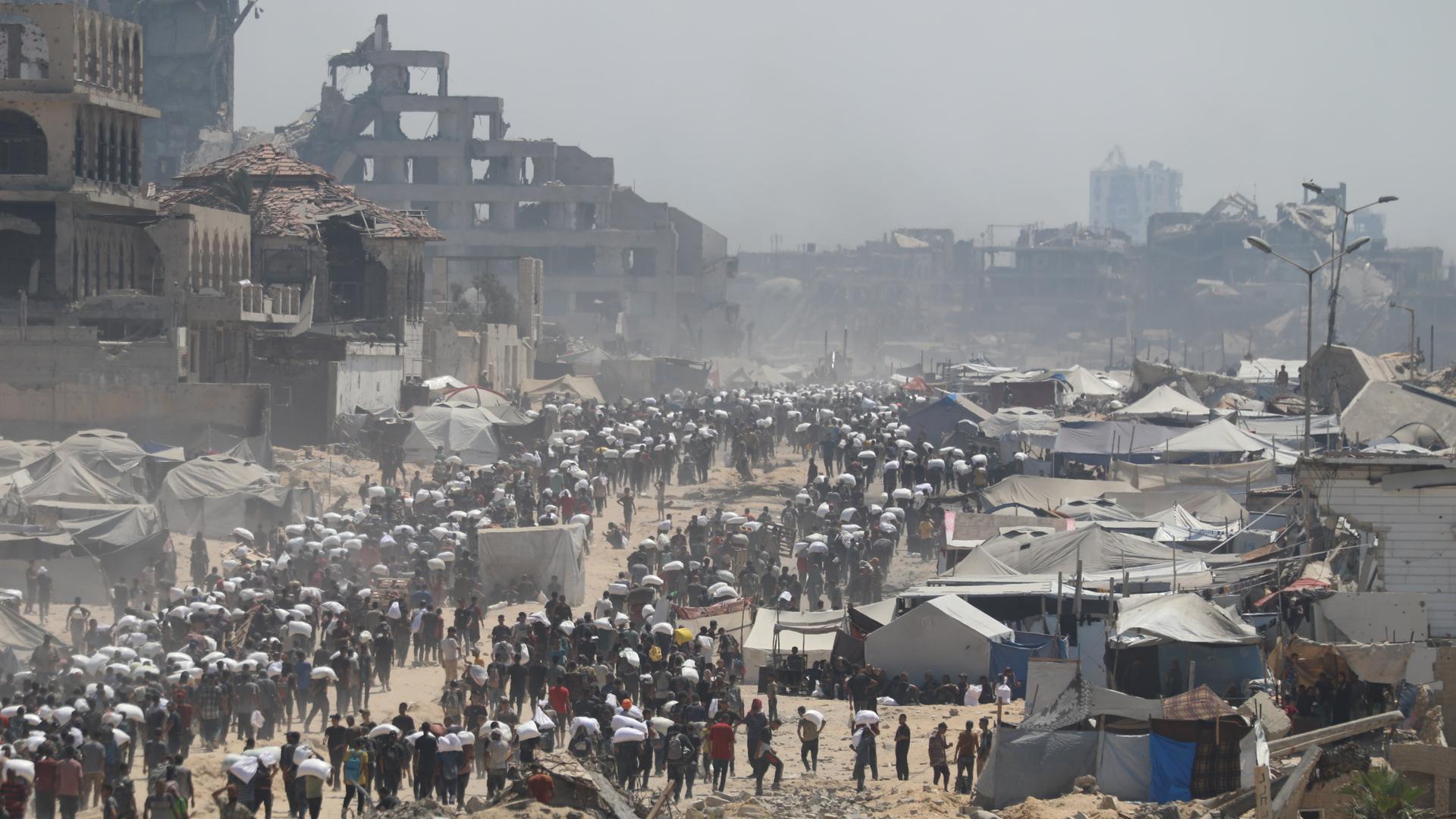 27. Juli 2025, Gaza City: Menschen auf der al-Rashid Straße in West-Jabalia auf dem Weg in den Norden.