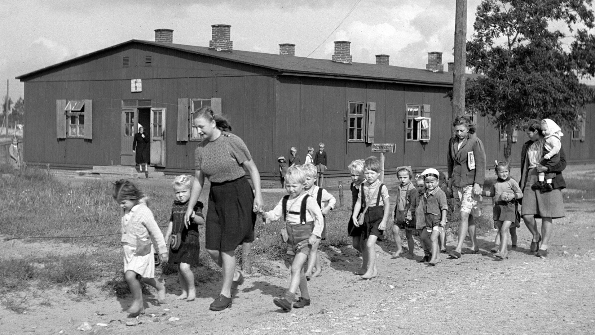 Historisches Foto einer Gruppe von Kindern mit Betreuerinnen in einem Lager für deutsche Flüchtlinge in Oxböl, Dänemark, 1948.