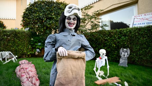 Gruselige Figuren auf einem Rasen vor einem Haus.