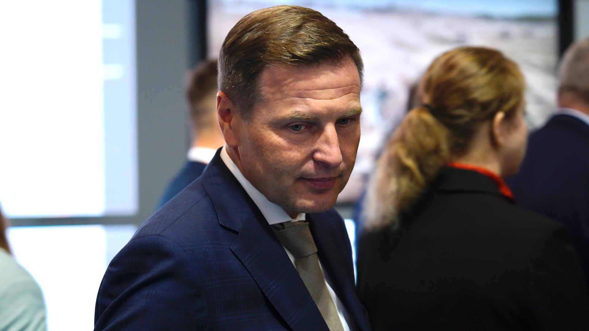 Estlands Verteidigungsminister Hanno Pevkur besucht eine Verteidigungsmesse in Polen. Er ist in der Halbtotalen zu sehen und trägt einen blauen Anzug.