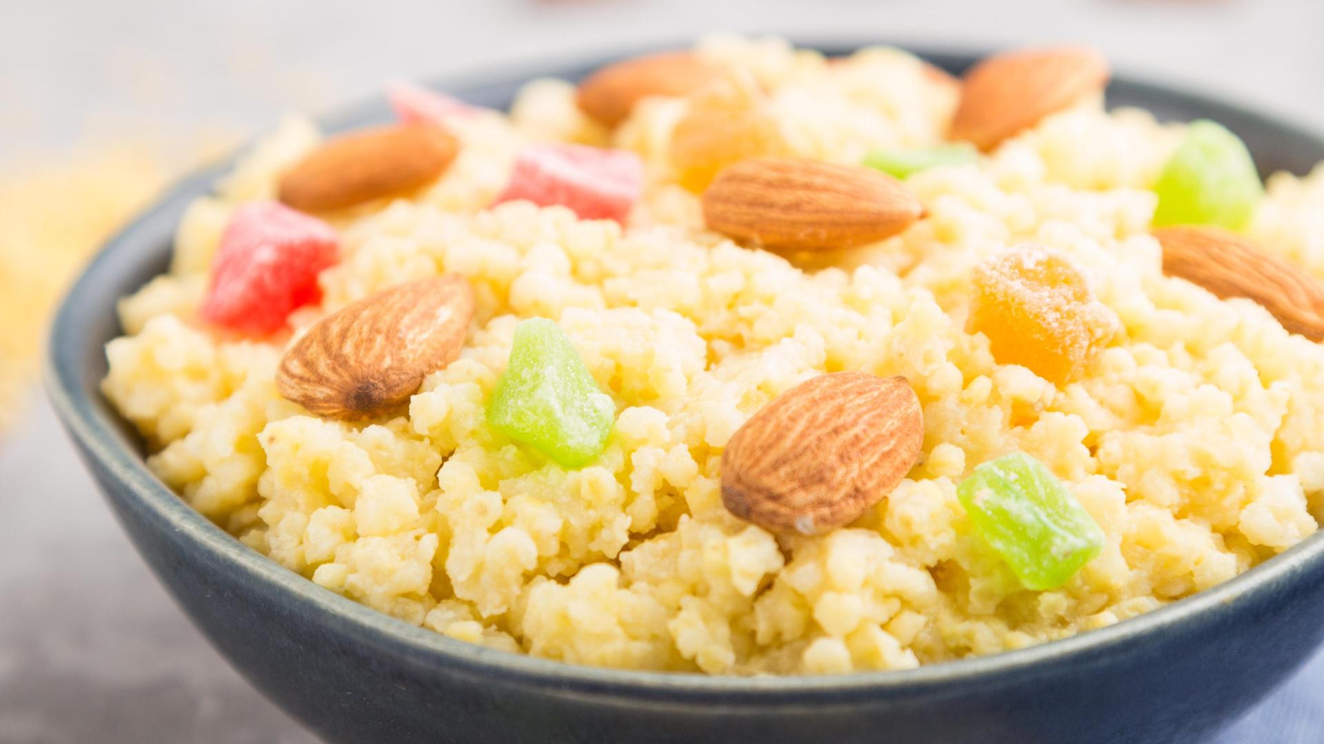 Hirsebrei mit kandierten Früchten und Mandeln in einer Keramikschale