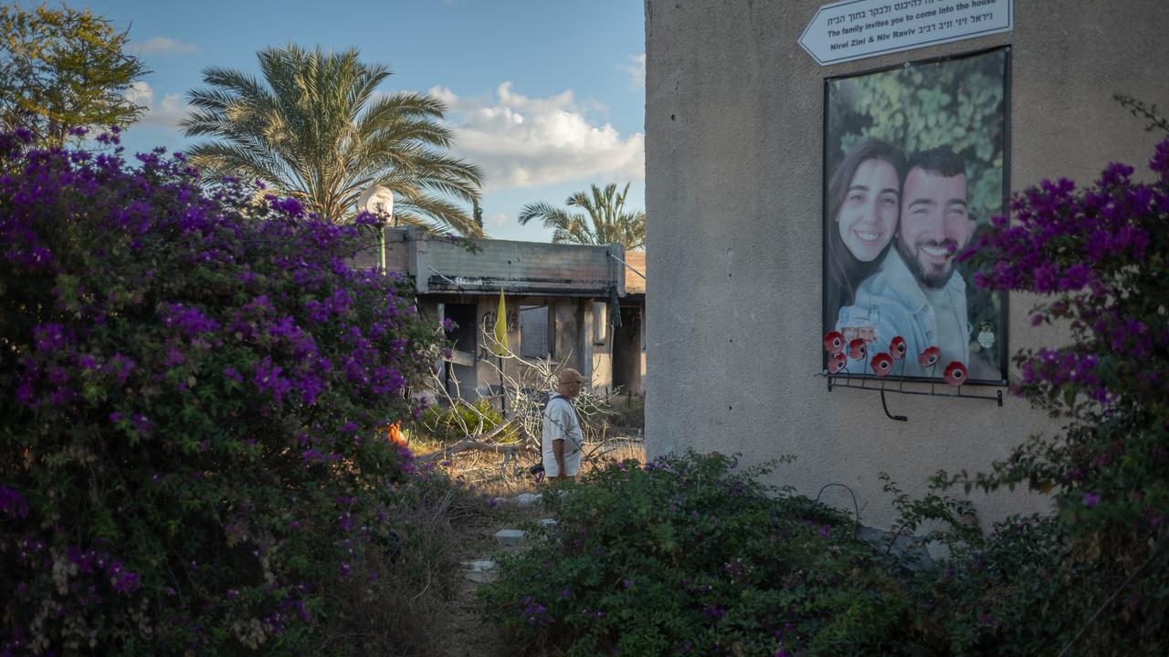 Ein Mann geht während einer Zeremonie zum zweiten Jahrestag des von der Hamas angeführten Angriffs vom 7. Oktober an einem Foto eines Paares in Kfar Aza vorbei.