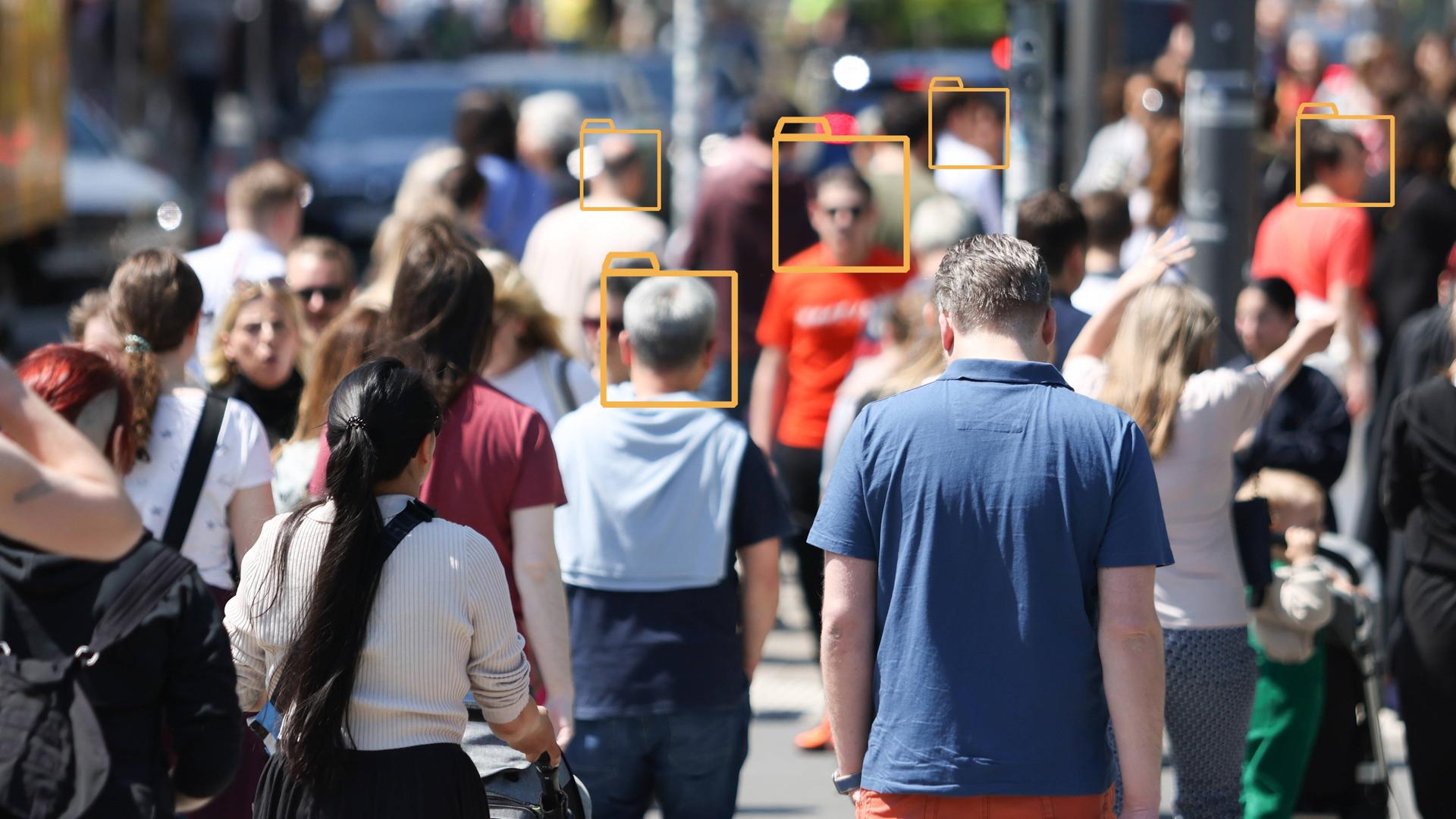 Unscharfes Bild einer Menschenmenge in einer Fußgängerzone. Über manche Gesichter wurden grafische Symbole von Aktenordnern gelegt.