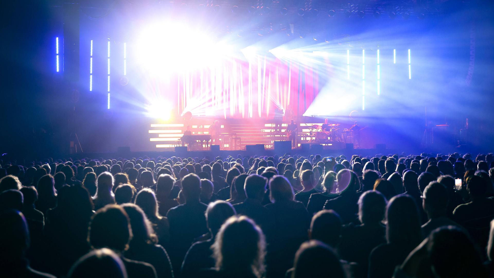 In der gut gefüllte Mitsubishi Electric Halle während eines Sasha-Konzertes strahlt das Licht von der Bühne über das Publikum