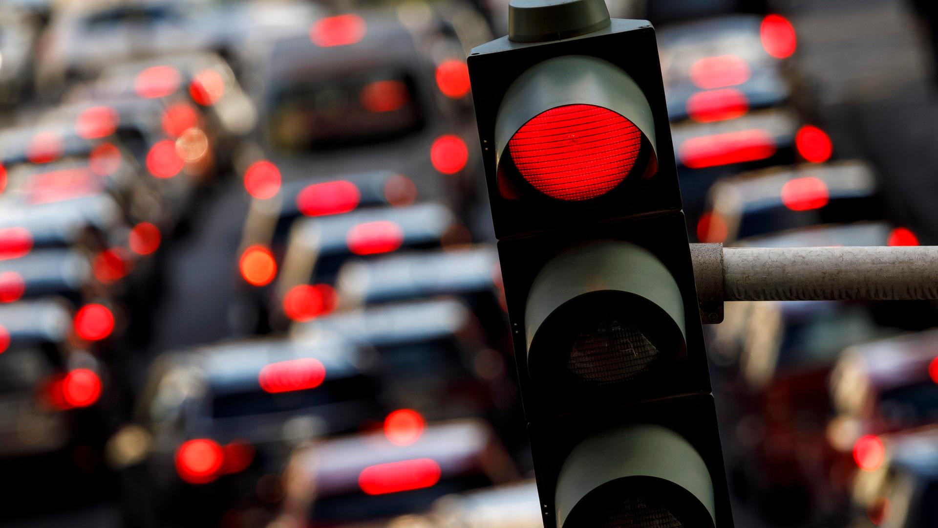 Eine rote Ampel auf der Tunisstraße in Köln, auf der Straße viele Autos mit leuchtendem Rücklicht
