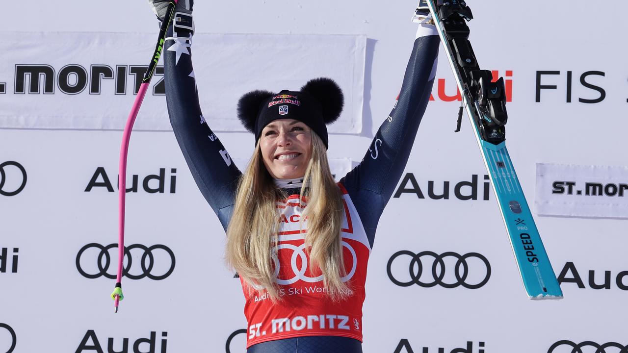 Lindsey Vonn hält einen Skistock und eine Skier hoch und jubelt.
