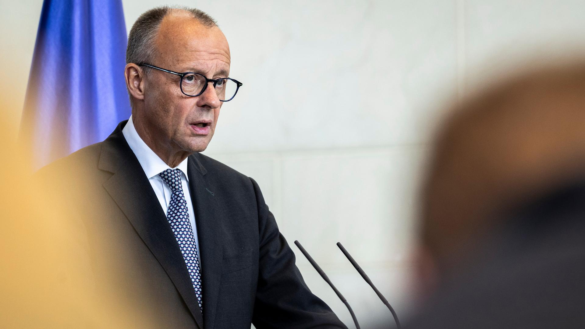 Bundeskanzler Friedrich Merz (CDU) steht an einem Rednerpult und spricht.