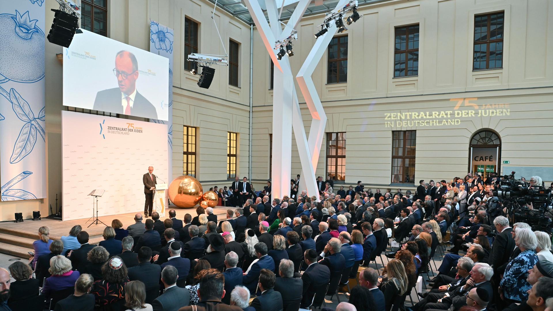 Bundeskanzler Merz auf der Bühne bei den Feierlichkeiten zum 75. Jubiläum des Zentralrats der Juden