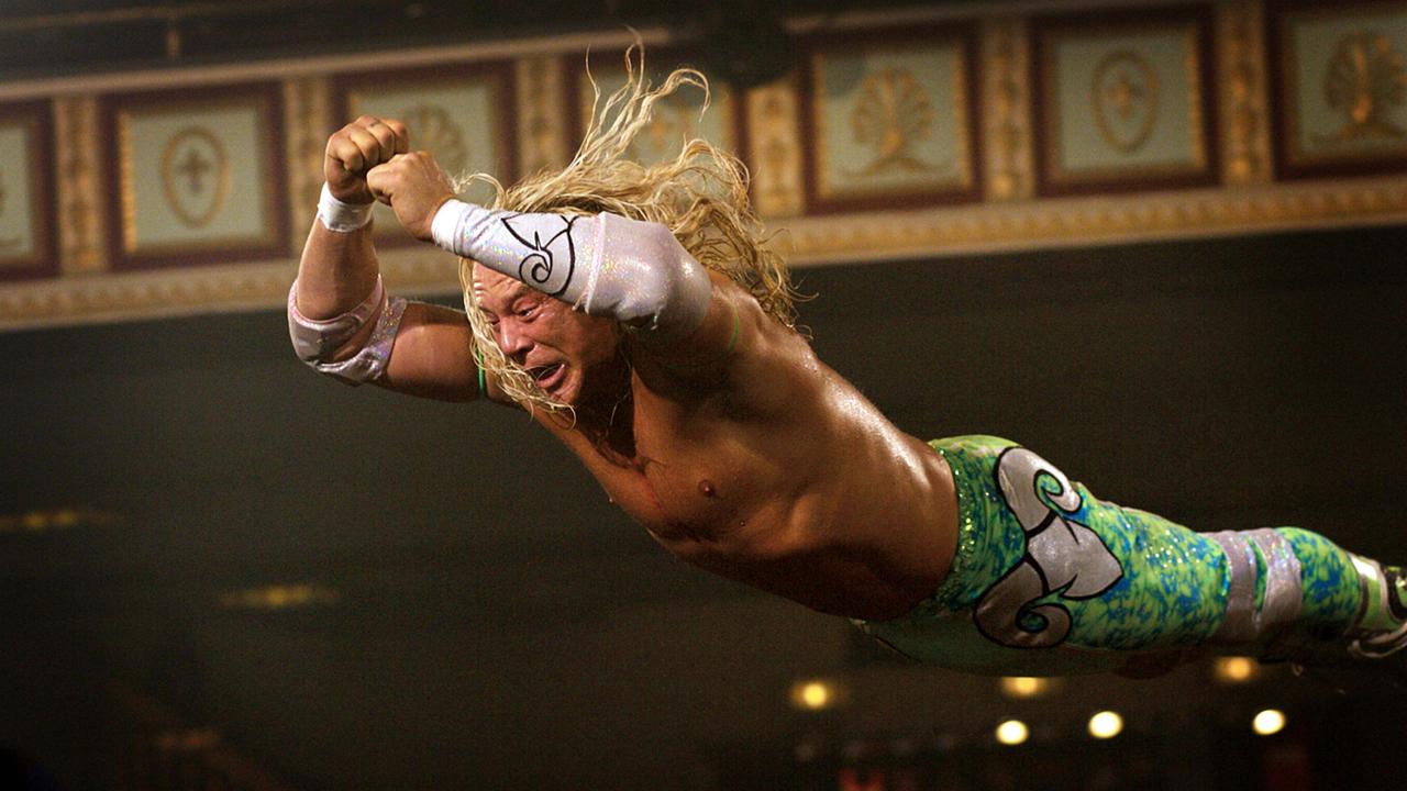 Eine Filmszene aus dem Film "The Wrestler" zeigt den Schauspieler Mickey Rourke mit langen Haaren und bunter Kampfsporthose bekleidet. Er springt mit wehenden Haaren durch die Luft.