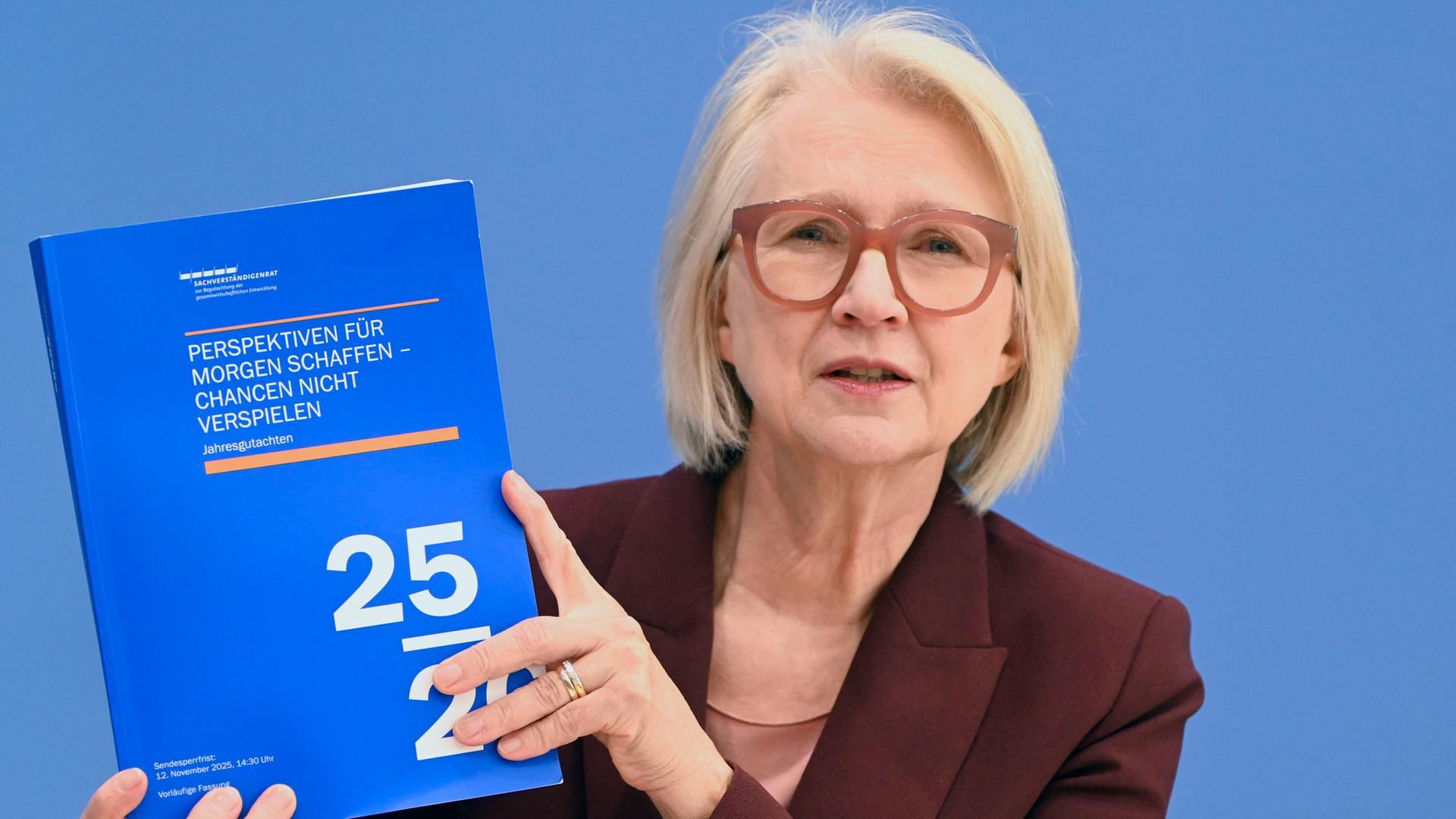 Monika Schnitzer stellt Jahresgutachtens 2025/26 des Sachverständigenrat zur Begutachtung der gesamtwirtschaftlichen Entwicklung' im Haus der Bundespressekonferenz vor. Sie hält es als blaue Broschüre in den Händen. 