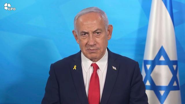 In diesem Bild aus einem vom Presseamt der israelischen Regierung veröffentlichten Video gibt der israelische Ministerpräsident Benjamin Netanjahu eine Erklärung ab. Er steht neben einer israelischen Fahne. 