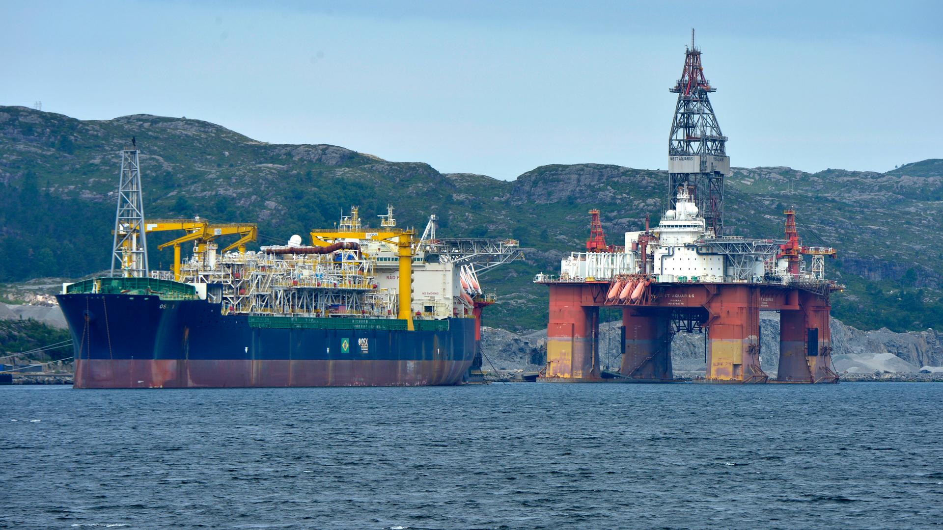 Eine Bohrinsel und ein Frachter in einem norwegischen Fjord