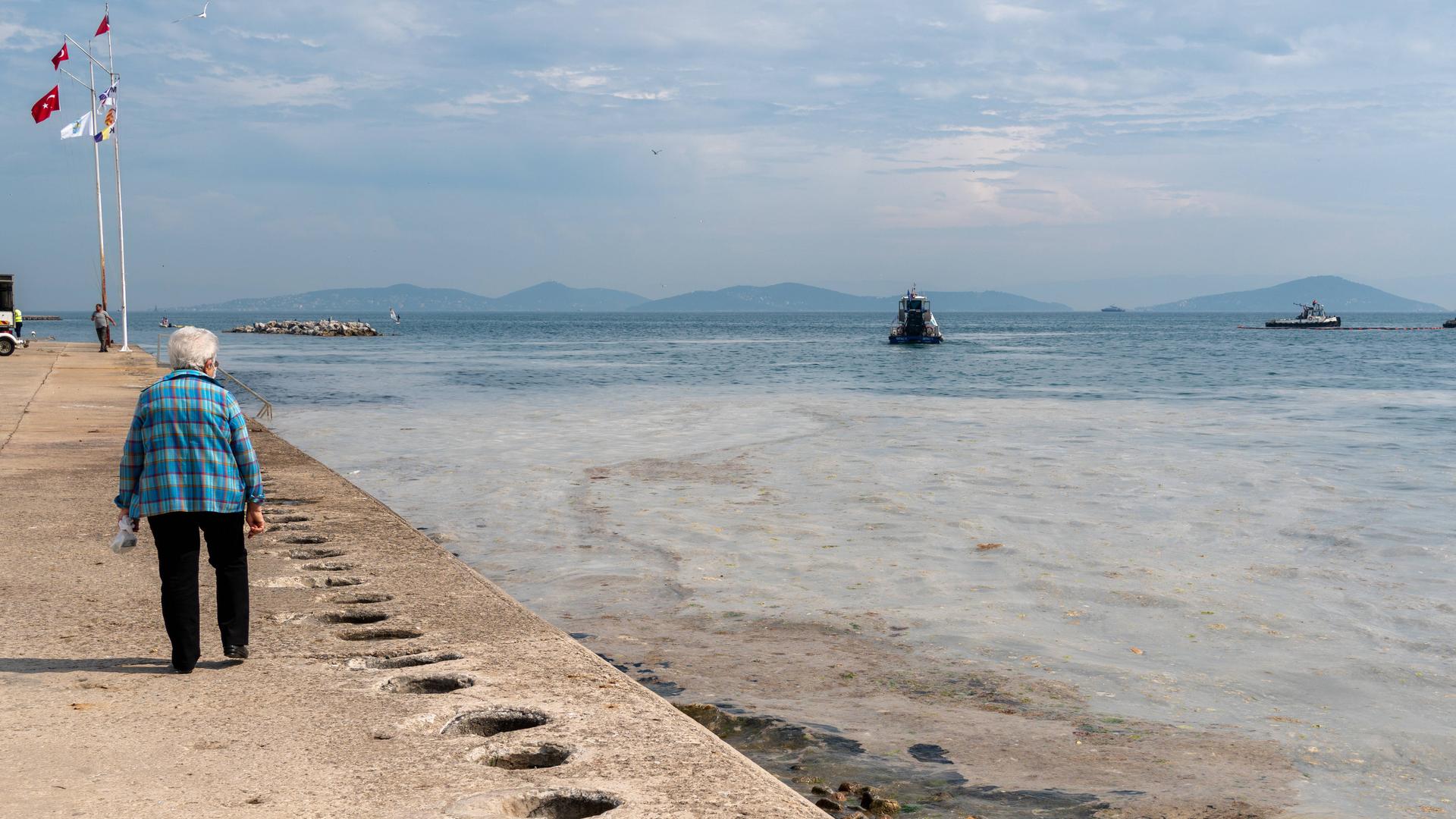 Eine Frau blickt auf das Meer.