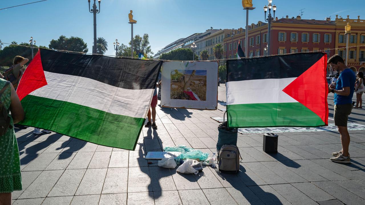 Während einer Demonstration in Nizza werden von zwei Demonstranten zwei Palästina-Flaggen aufgespannt.
