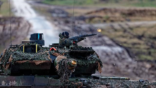 Auf dem Bild feuert ein Soldat aus einer Bordwaffe des Leopard 2A6 Kampfpanzer. 