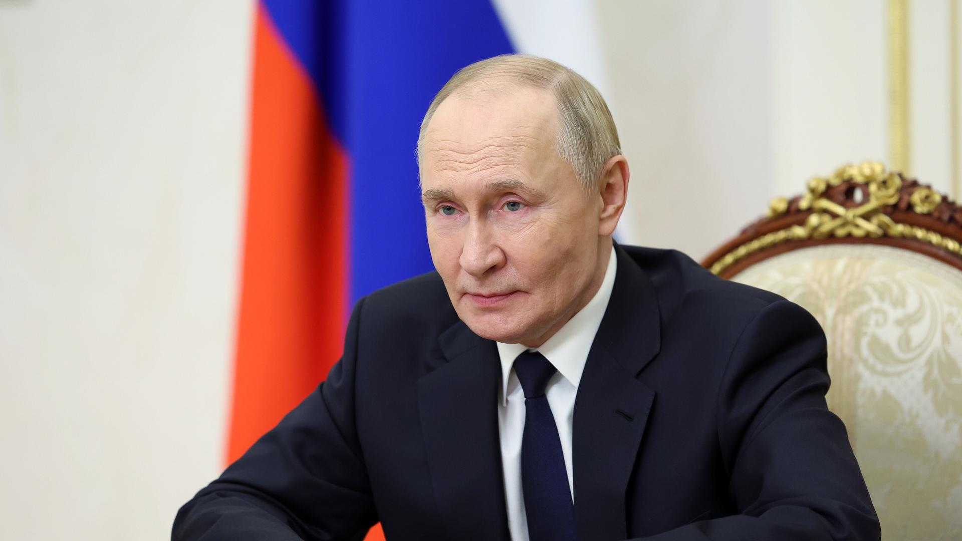 Der russische Präsident Wladimir Putin sitzt an einem Tisch und spricht in eine Kamera.