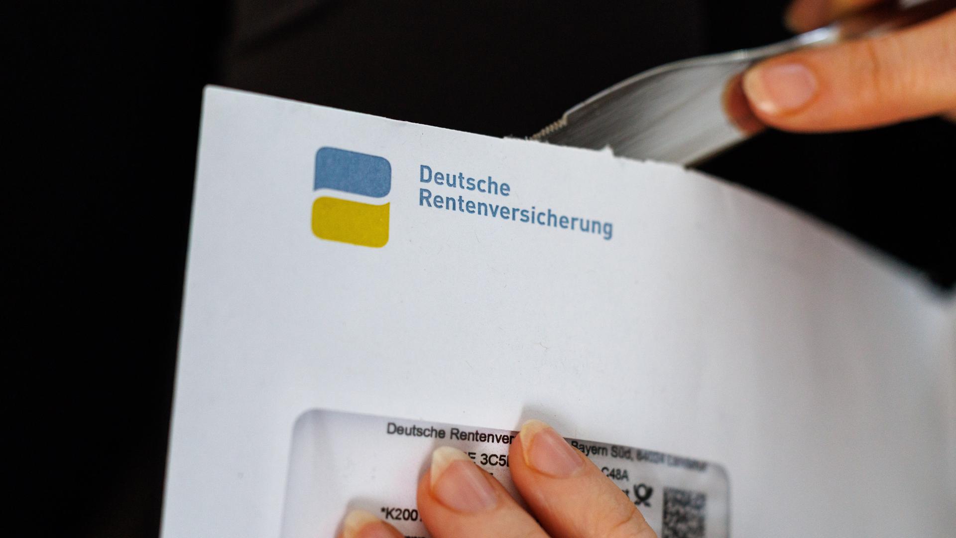Eine Frau öffnet einen Briefumschlag, auf dem das Logo und der Schriftzug der deutschen Rentenversicherung zu sehen ist.