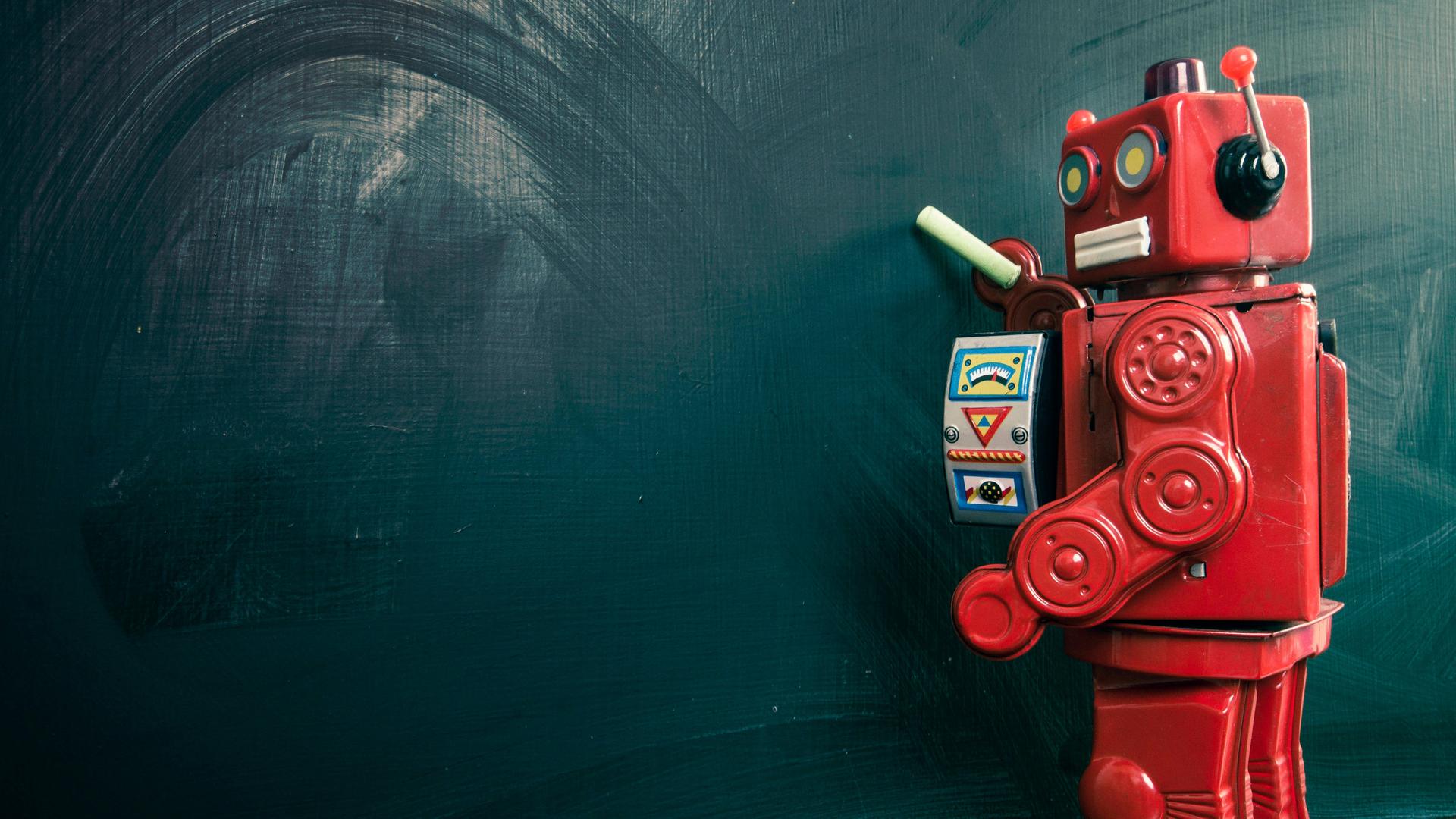 Roboter mit Kreide an einer leeren Tafel