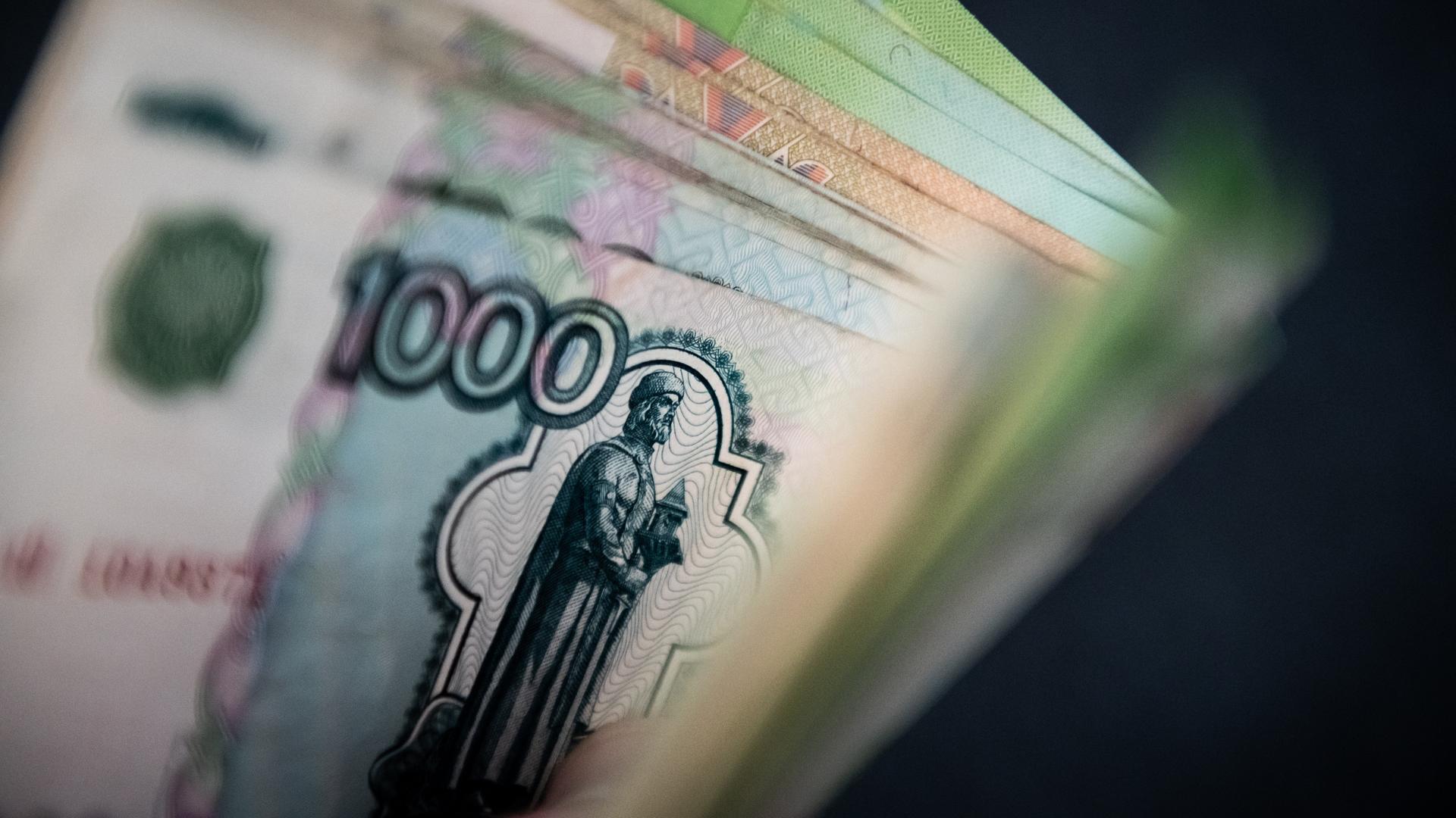 Ein Mann hält Rubelscheine in der Hand